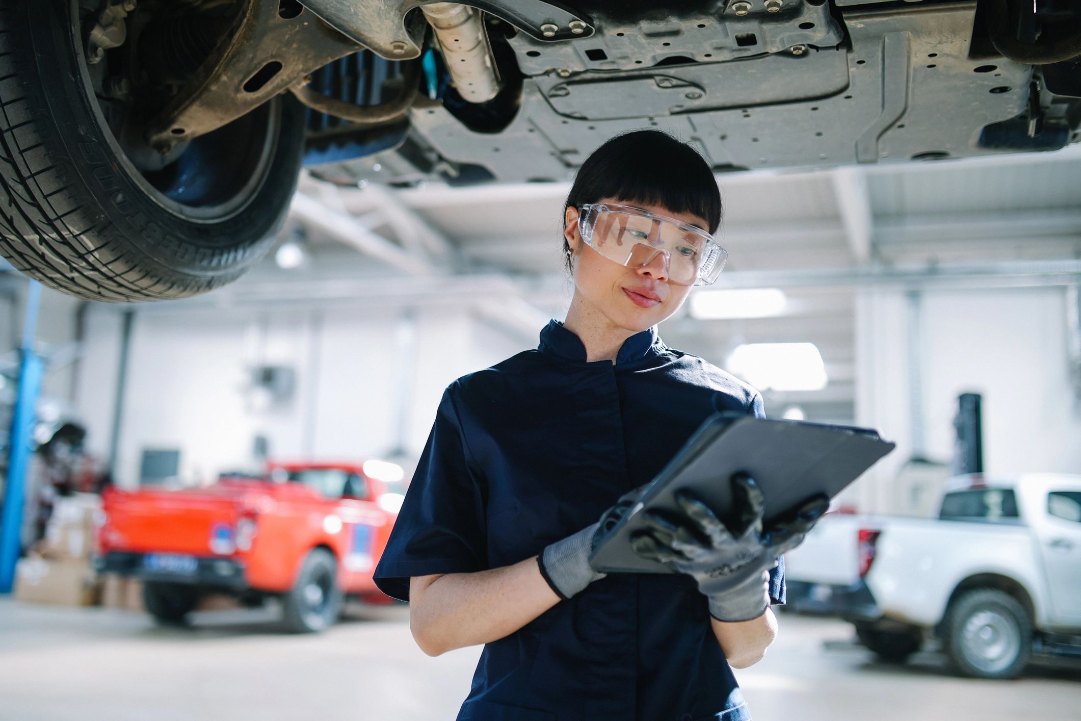 Technician inspecting a vehicle with a tablet